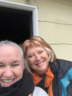 Two ladies standing outside a fire damaged house
